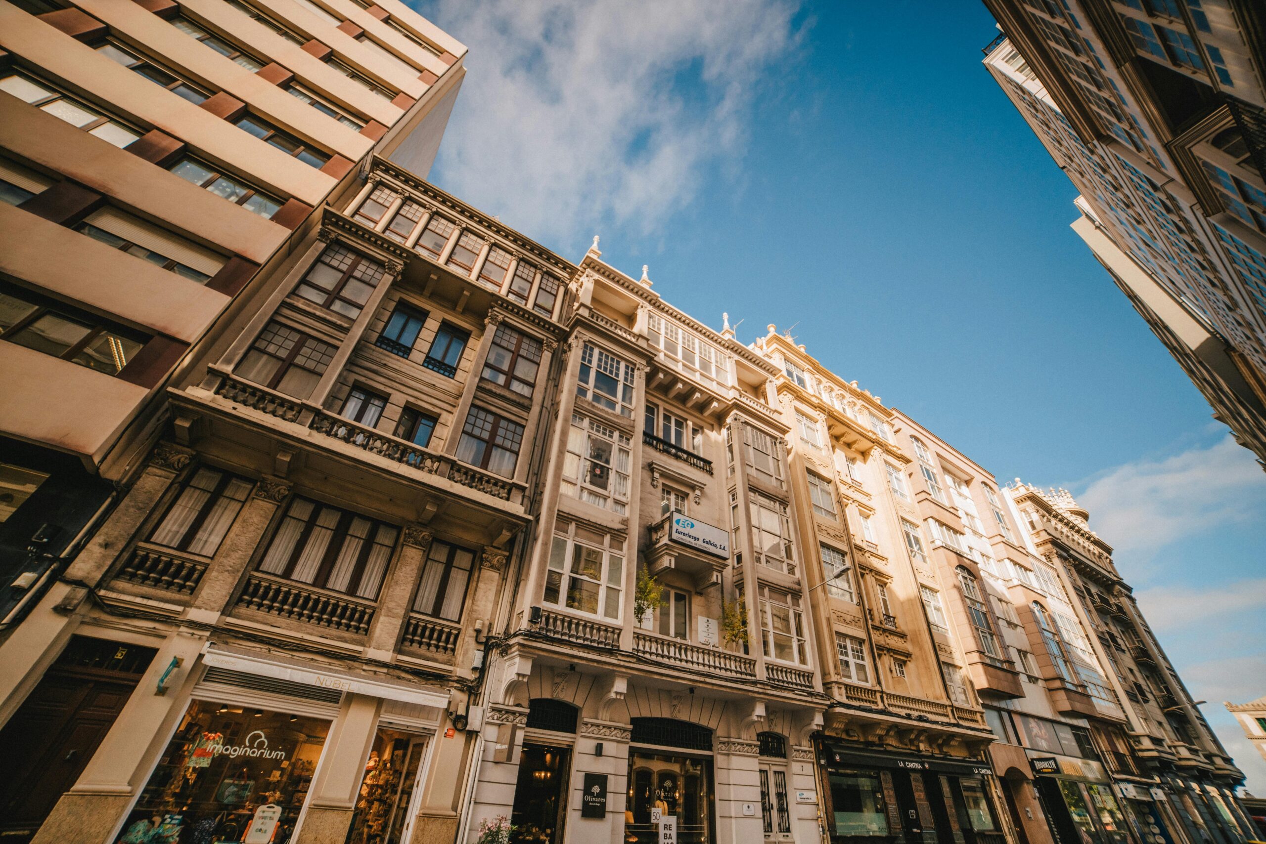 A low-angle view of elegant urban buildings against a blue sky.